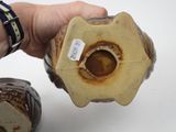 a person holding a piece of pottery with a tag on it
