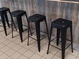quatre tabourets noirs placés devant un comptoir