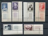 quatre timbres différents, représentant des visages variés, sur fond noir