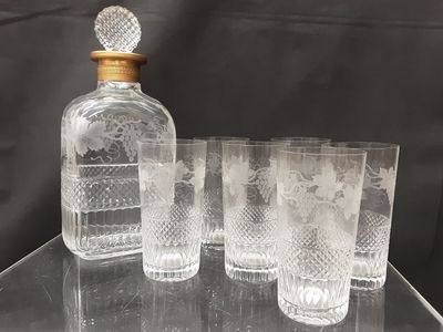 four glasses and a decanter sitting on a table