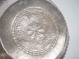 a silver vase with a decorative design on it