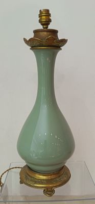 a green lamp that is on top of a glass table