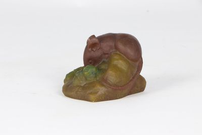 figurine of a mouse on a rock on a white background