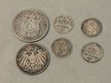 Six types différents de pièces allemandes sont exposés sur une table.