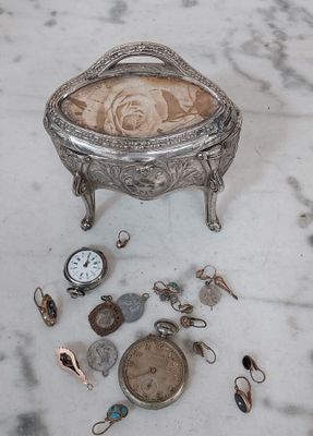 une boîte en argent surmontée d'une horloge, posée sur une table en marbre
