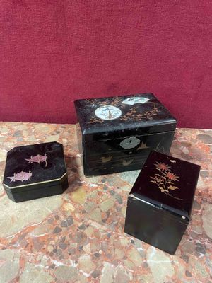 three small black boxes sitting on top of a marble table
