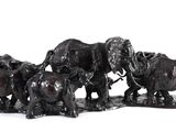 a group of elephants that are standing together on a white surface