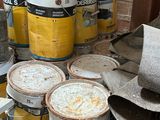several buckets of paint are sitting on a pallet in a room