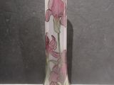un vase en verre orné de fleurs roses, posé sur une table