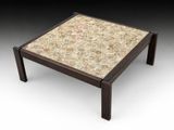 un gros plan d'une table basse avec un plateau en carrelage