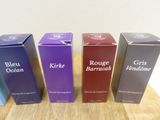 three boxes of blue, purple, and red wine sitting on a table