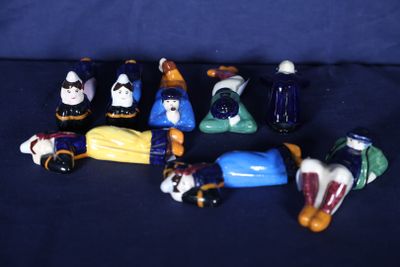 de nombreuses figurines représentant des personnes assises sur une surface bleue