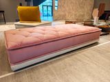 a pink ottoman sitting on the floor in a living room