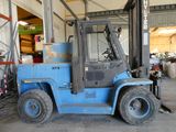 un chariot élévateur bleu garé dans un entrepôt