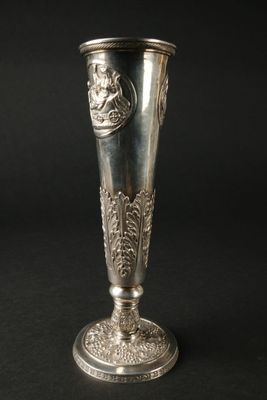 un vase en argent orné d'un lion sur fond noir