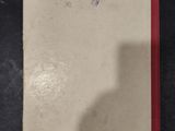 an old book sitting on top of a table with a shadow of a person on it