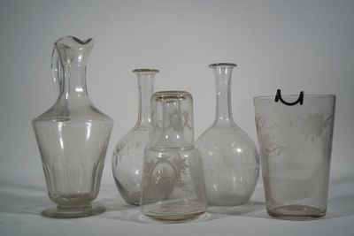 three glass vases and a glass cup sitting on a table