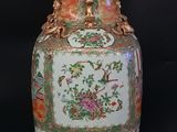 a vase with a floral design on it sitting on a black surface