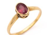 gros plan d'une bague en or avec une pierre en rubis