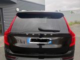 the back end of a black volvo suv parked in front of a building
