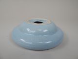 a blue vase that is sitting on a white table