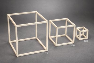 trois cubes de tailles différentes posés sur une surface grise