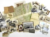 a pile of old photographs and old postcards on a table