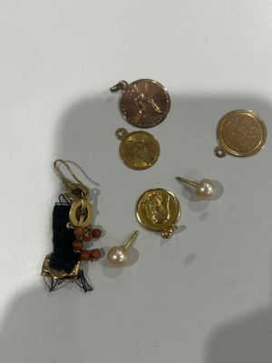 a small collection of gold and silver jewelry on a white surface