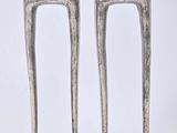 two silver candles that are sitting on a stand