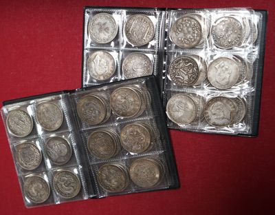 two boxes of silver coins sitting on top of a red surface