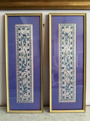 deux tableaux encadrés représentant des fleurs bleues et blanches, accrochés au mur