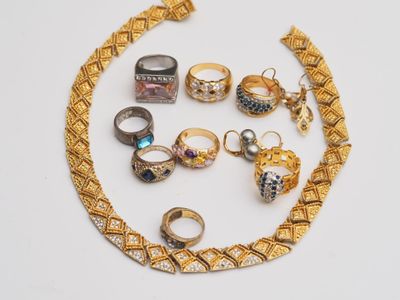 a lot of rings and bracelets on a white surface
