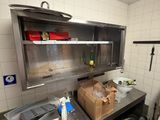 une cuisine équipée d'un évier, d'une cuisinière et d'autres éléments posés sur le plan de travail