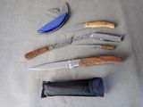 several different types of knives are laid out on a table