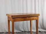 une photo d'une table en bois avec un rideau blanc en arrière-plan
