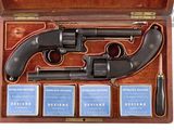 gun in a wooden case with four cards and a lighter