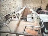 a boat that is sitting in a garage next to a car