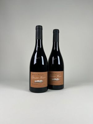 deux bouteilles de vin posées sur une table blanche