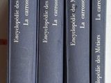 Quatre livres bleus sont alignés sur une table blanche