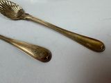 two spoons and a fork on a white table