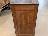 a wooden cabinet with a marble top in a room