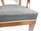 une image représentant une chaise en bois avec une assise rembourrée grise