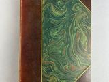 a book with a green and brown cover sitting on a table