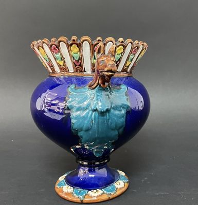 un vase bleu surmonté d'une couronne dorée