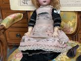 a doll that is sitting on a chair in a room