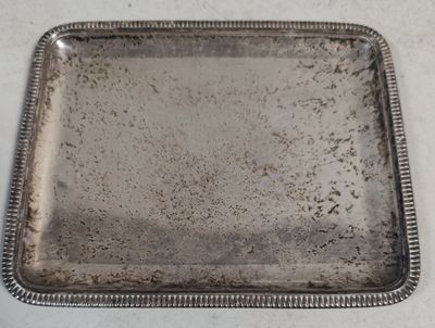 assiette rectangulaire en argent plaqué, avec un bord festonné sur fond blanc