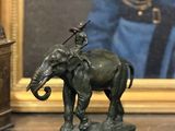 une statue représentant un éléphant avec un oiseau sur le dos