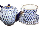 a blue and white tea pot and cup on a saucer