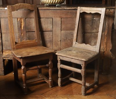 two wooden chairs sitting next to each other on a wooden floor