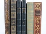 plusieurs vieux livres sont alignés sur une surface blanche